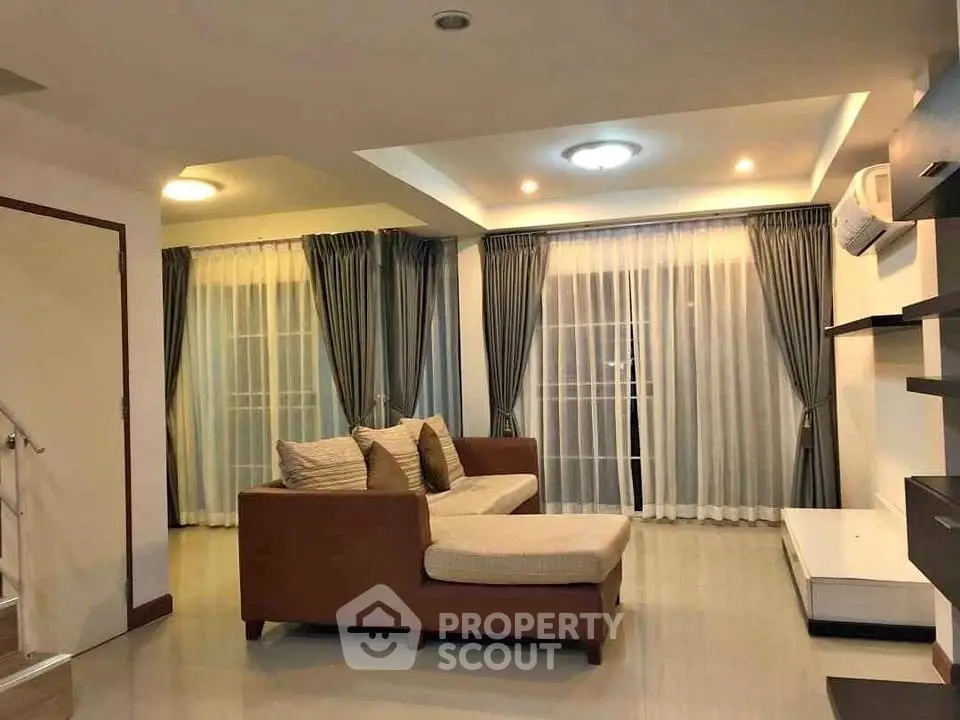 Spacious living room with modern decor and large windows for natural light