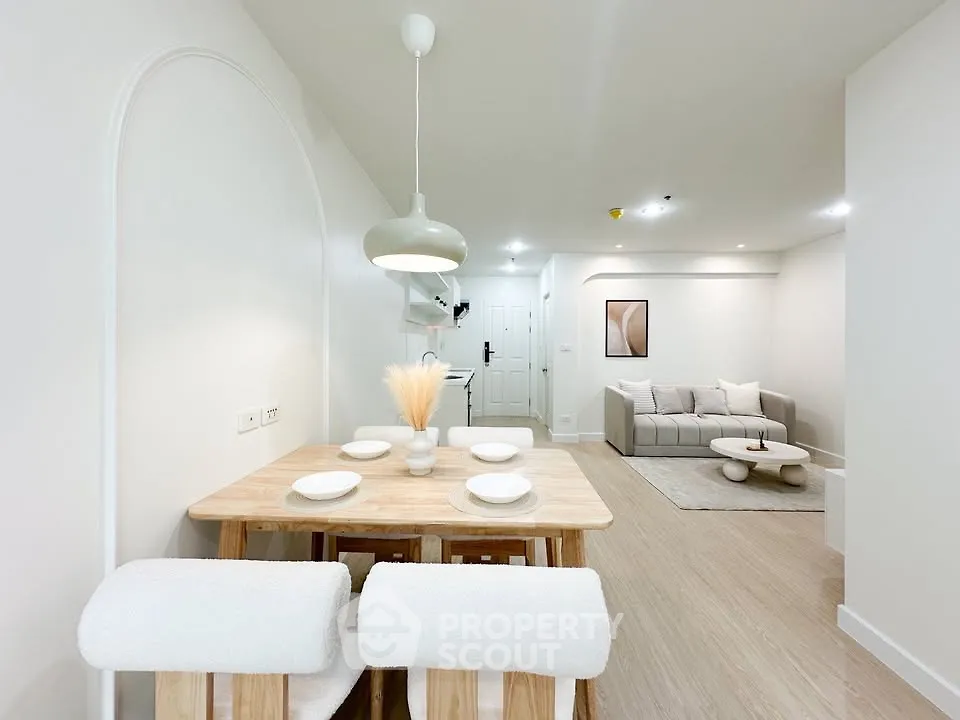 Modern open-plan living and dining area with minimalist decor and neutral tones.