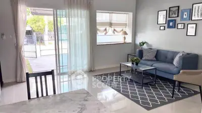 Modern living room with stylish decor and large windows offering natural light and garden view.