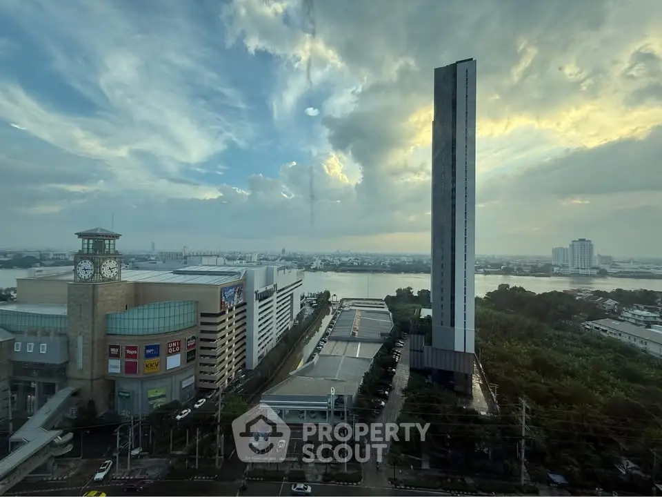 Breathtaking cityscape view with modern high-rise building and river at sunset.