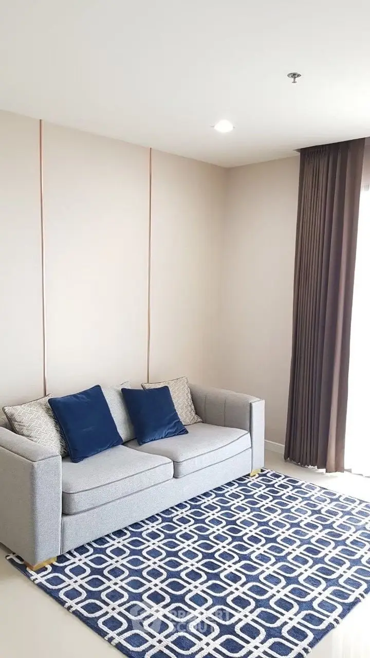 Modern living room with stylish sofa and geometric rug, perfect for cozy relaxation.