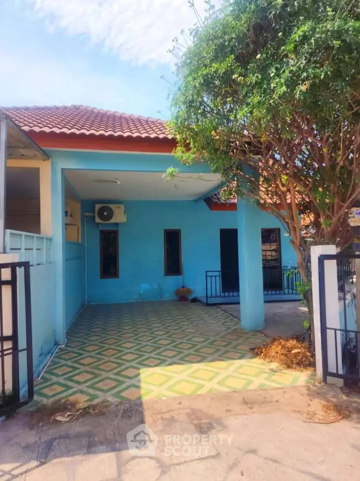 Charming single-story home with blue exterior and spacious driveway, perfect for family living.