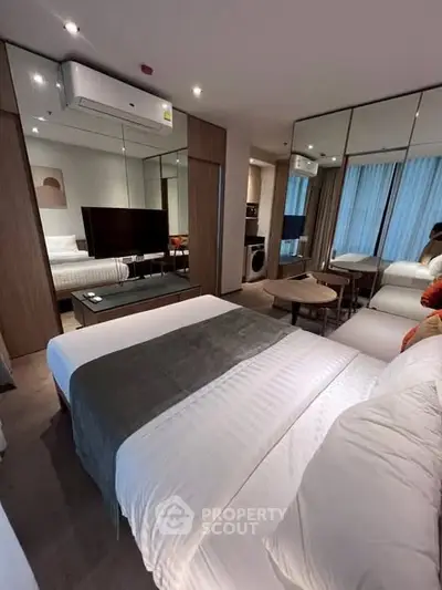 Modern bedroom with mirrored walls and cozy decor in a stylish apartment.