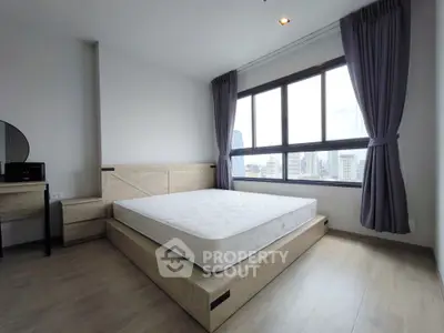 Spacious bedroom with large windows offering stunning city views, featuring modern furniture and elegant decor.