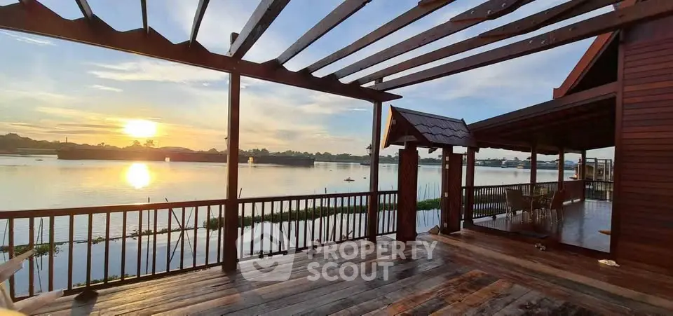 Stunning waterfront view from a spacious wooden deck at sunset, perfect for relaxation and entertainment.