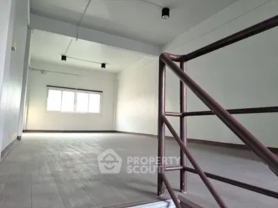 Spacious open-plan room with modern flooring and ample natural light, perfect for versatile living or office space.