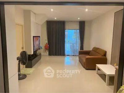 Spacious living room with modern decor and large window for natural light.