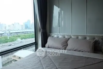 Modern bedroom with large window offering stunning city view