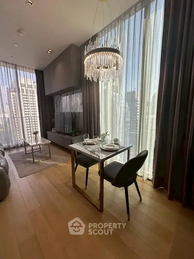 Luxurious modern living room with elegant chandelier and floor-to-ceiling windows in high-rise apartment.