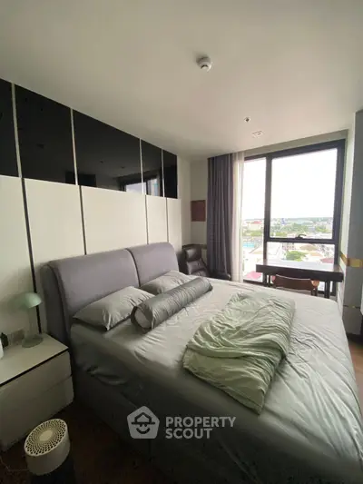 Modern bedroom with large window offering city view and stylish decor