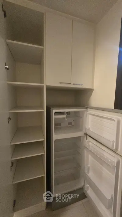 Spacious kitchen storage with built-in fridge and ample shelving for modern convenience.