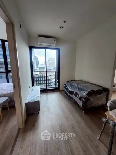Modern living room with city view and balcony access in high-rise apartment