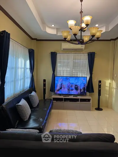 Cozy living room with elegant chandelier and modern entertainment setup