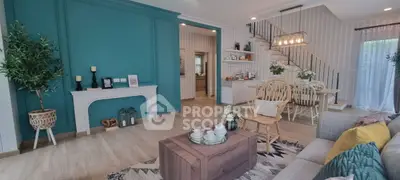 Charming living room with teal accent wall and cozy dining area, perfect for family gatherings.
