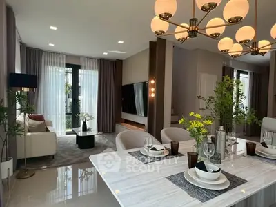 Luxurious open-plan living and dining area with elegant decor and modern lighting.