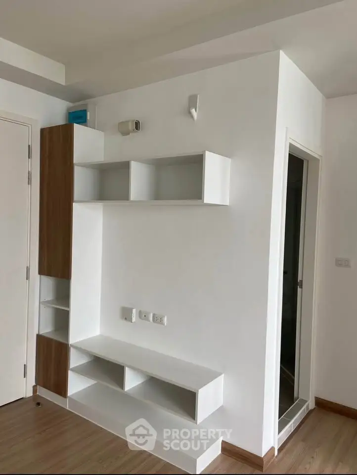 Modern minimalist interior with built-in shelving and wooden flooring, perfect for stylish living.