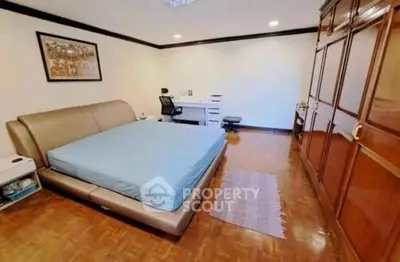 Spacious bedroom with modern furniture and wooden flooring, ideal for comfort and style.