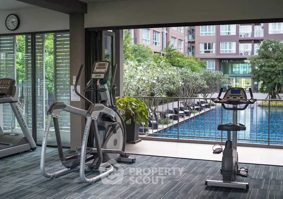 Modern gym with pool view in luxury apartment complex