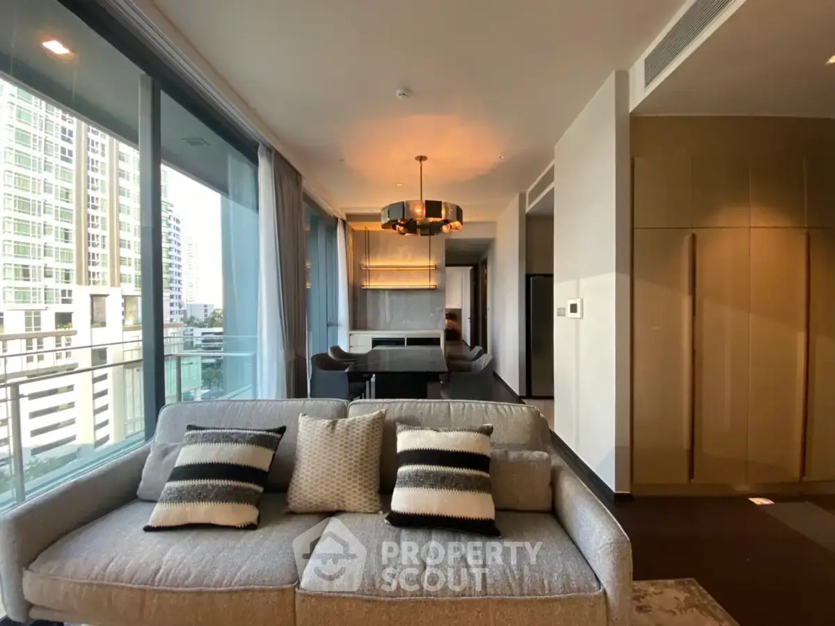 Luxurious modern living room with large windows and elegant decor in high-rise apartment.