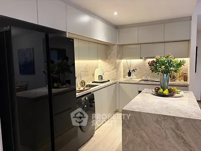 Modern kitchen with sleek cabinetry, marble island, and integrated appliances in a stylish home.