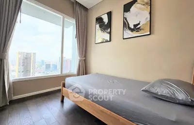 Modern bedroom with large window and city view, featuring stylish decor and natural light.