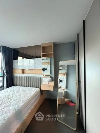 Modern bedroom with stylish decor and large mirror in a high-rise apartment.