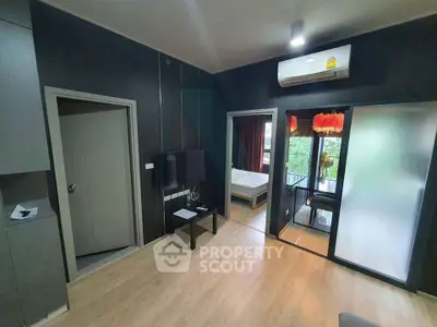 Modern apartment interior with sleek design, featuring a cozy living area and a glimpse of the bedroom.