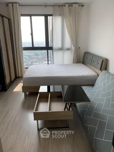 Modern bedroom with stylish furniture and large window offering city view