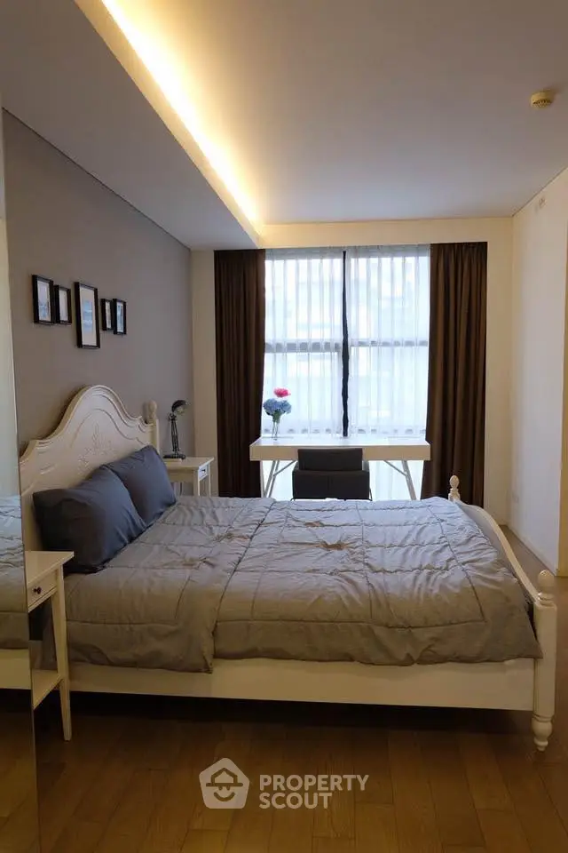 Elegant bedroom with cozy bed and natural light from large window.
