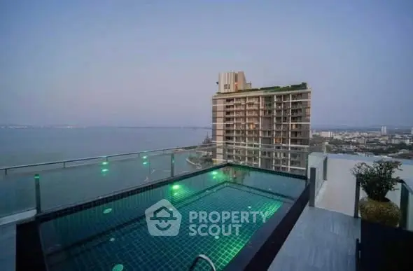 Stunning rooftop pool with panoramic city and ocean views in luxury high-rise building.