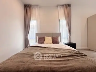 Elegant bedroom with cozy bed and stylish curtains in modern apartment.