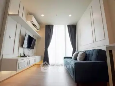 Modern living room with stylish sofa, wall-mounted TV, and elegant curtains in a bright apartment.