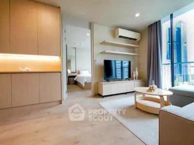 Modern living room with wooden flooring, cozy seating, and city view from balcony.