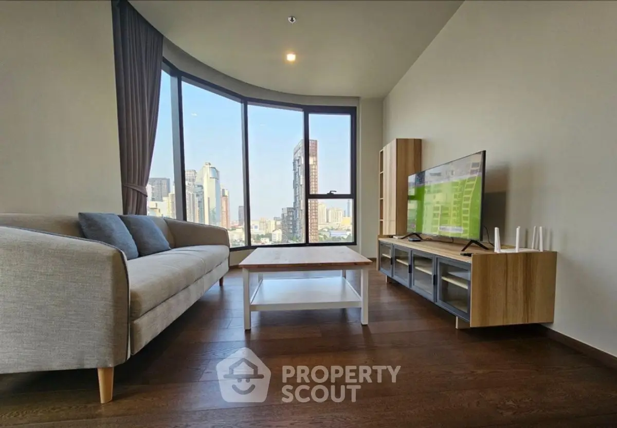 Modern living room with stunning city view, featuring sleek furniture and large windows.