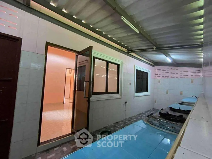 Spacious utility area with tiled flooring and ample natural light.