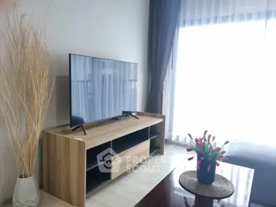 Modern living room with sleek TV stand and large window, perfect for relaxation.