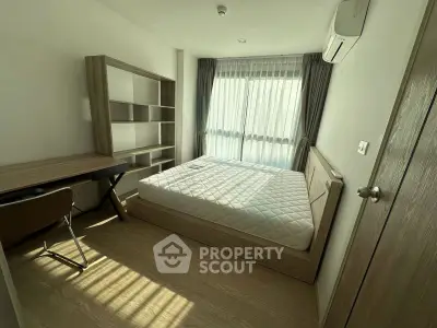 Modern bedroom with natural light, featuring a cozy bed, wooden desk, and stylish shelving unit.