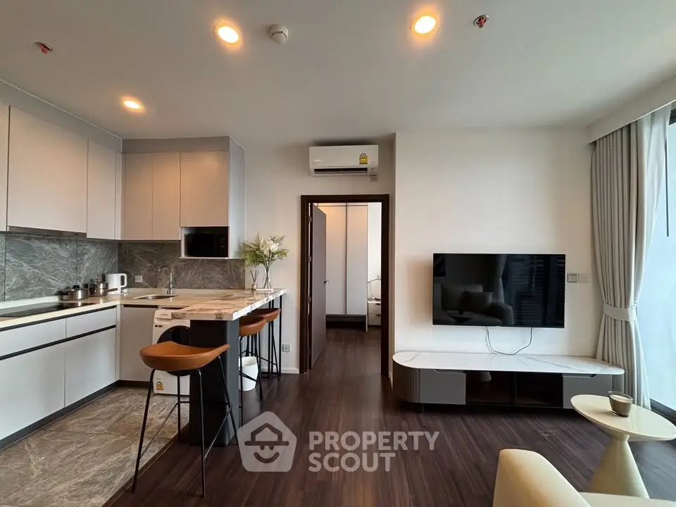 Modern open-plan living room with sleek kitchen and stylish decor