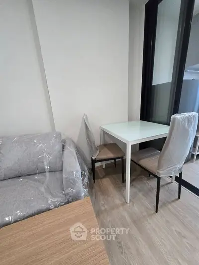 Modern living room with sleek furniture and wooden flooring, perfect for cozy urban living.