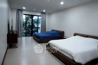 Spacious bedroom with two beds and large window view