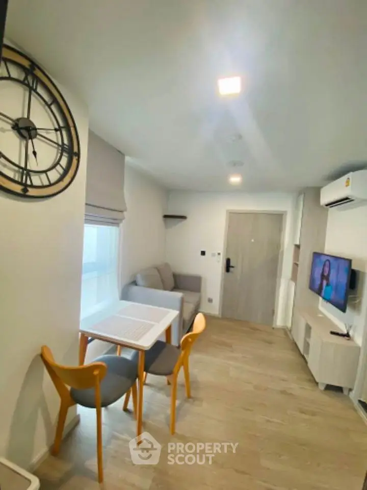 Modern living room with stylish decor and wall-mounted TV in a cozy apartment.