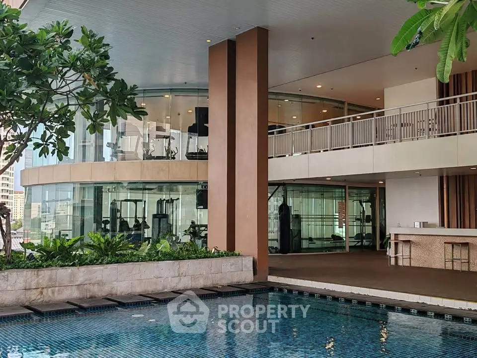 Luxurious modern building with pool and gym facilities, ideal for upscale living.