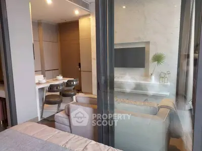 Modern living room with sleek furniture and dining area in open layout apartment.