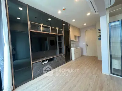 Modern living room with sleek built-in entertainment unit and open kitchen layout.