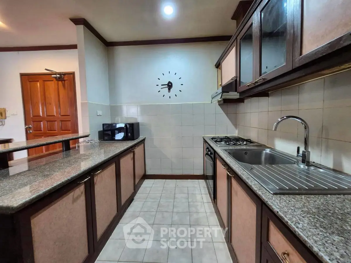 Spacious kitchen with granite countertops and gas stove in modern apartment