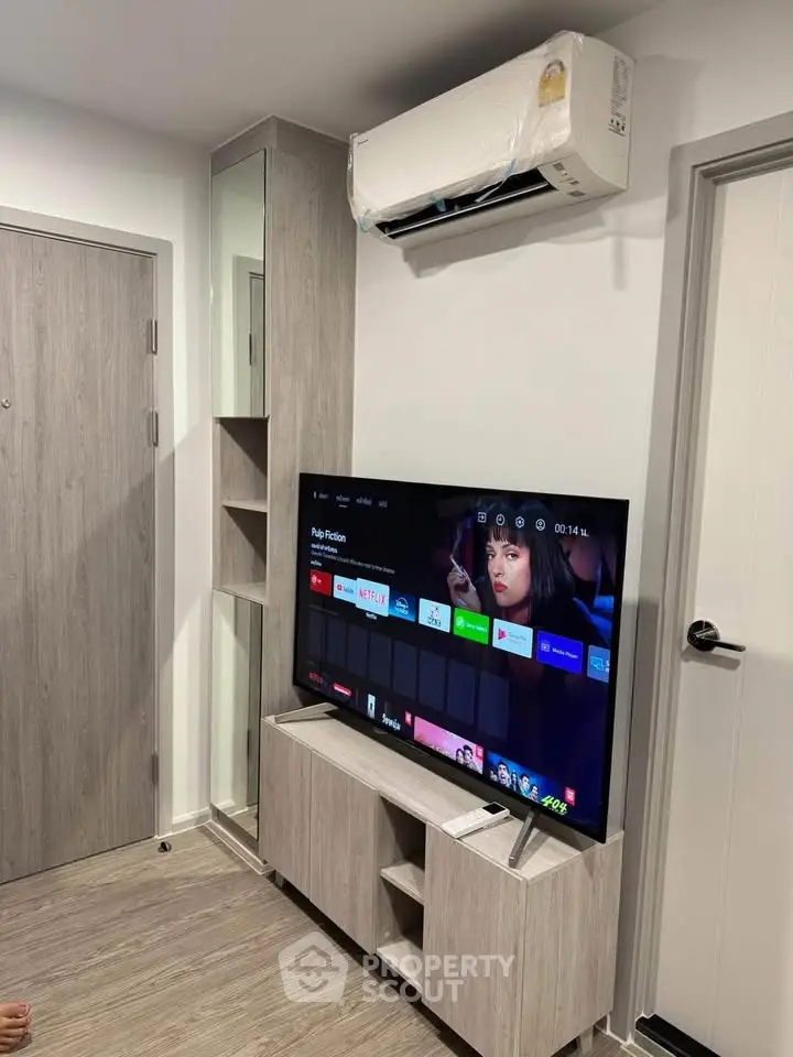 Modern living room with sleek TV setup and air conditioning unit