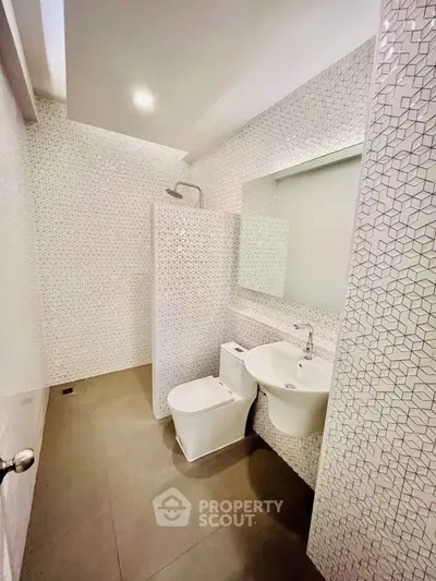 Modern bathroom with geometric tile design and sleek fixtures