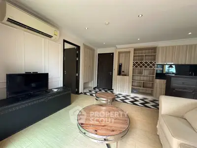 Modern living room with stylish decor and open layout, featuring a TV and air conditioning.