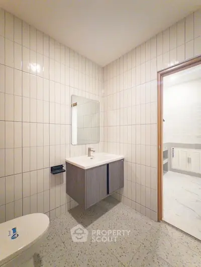 Modern bathroom with sleek vanity and tiled walls in a contemporary home.