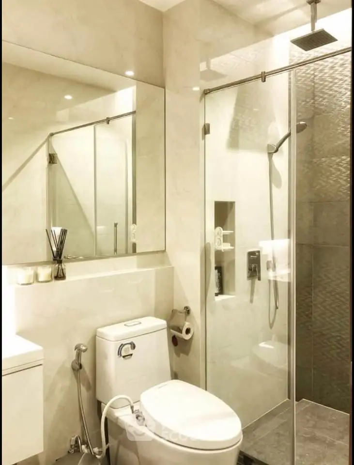 Modern bathroom with glass shower and sleek fixtures in luxury apartment.